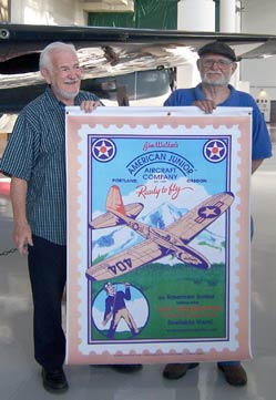 Frank Macy and Gil Coughlin hold an American Junior poster designed by Frank Macy