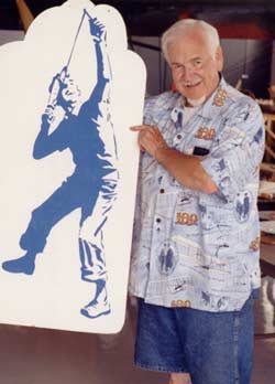 Frank Macy holding his artistic representation of a boy launching the folding wing Interceptor